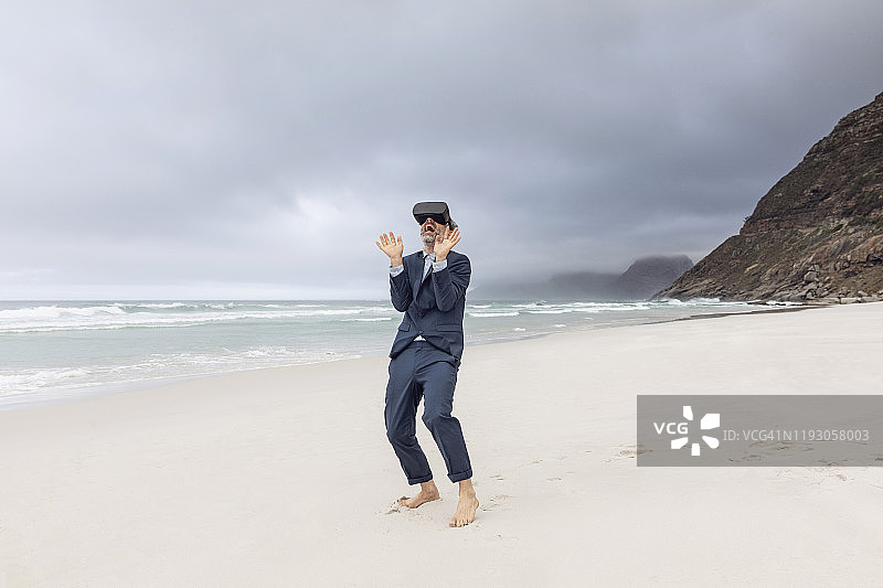 商人在南非西开普省诺德霍克海滩上使用VR眼镜图片素材