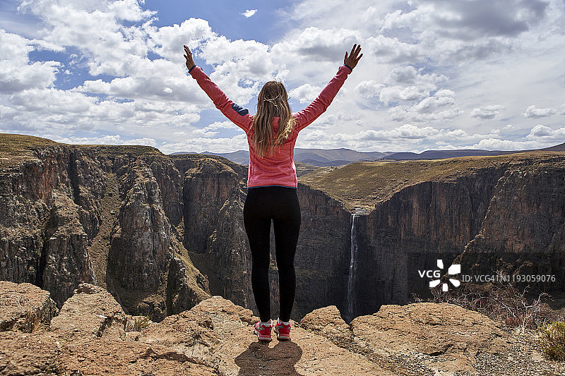 在莱索托马莱楚尼亚内瀑布欣赏风景的举起双臂的女人图片素材