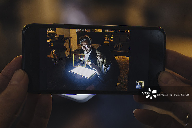 快乐的年长商人和女孩在办公室使用平板电脑看热气球的竖版照片图片素材