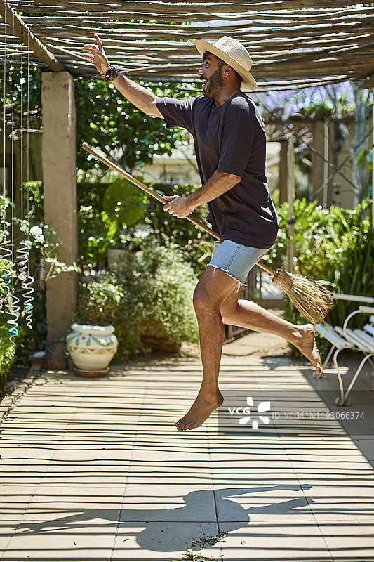 快乐的男人在户外骑着扫帚图片素材