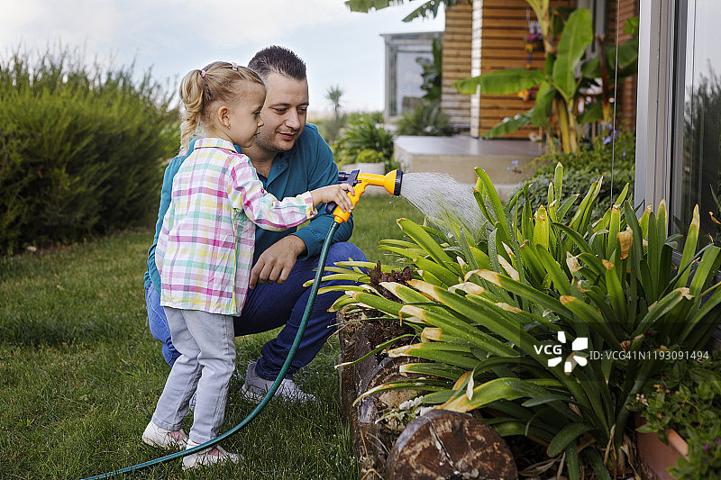 父女在花园里浇水图片素材