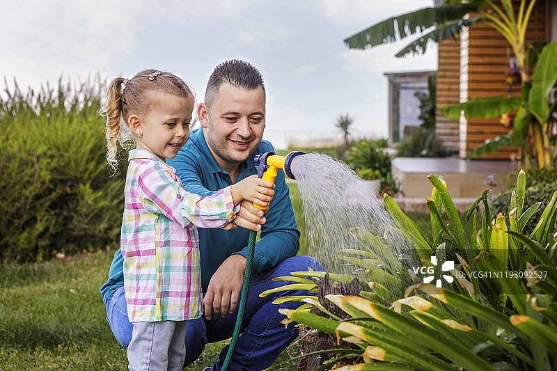 父女在花园里浇水图片素材