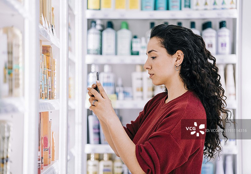 顾客用手机扫描美妆产品图片素材