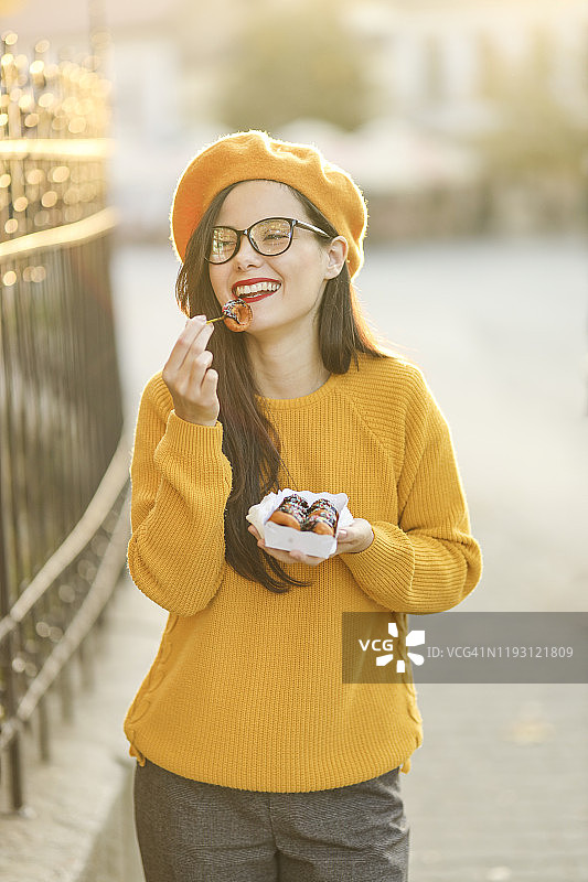 女人拿着巧克力甜甜圈图片素材