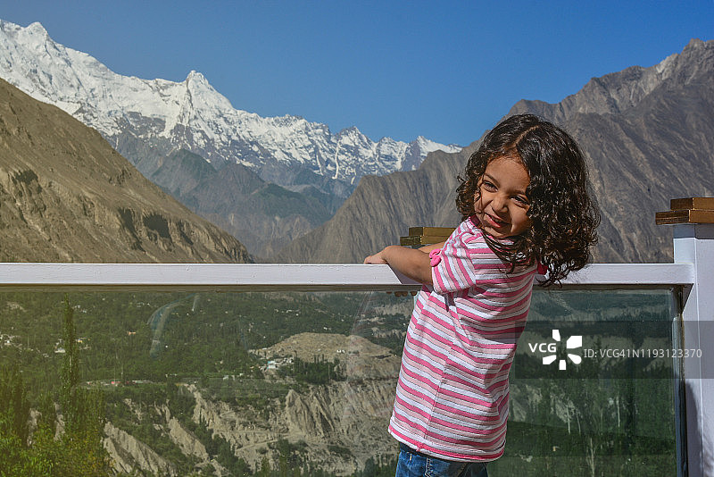 可爱的卷发小女孩在假期旅行时，站在拉卡波什山前进行户外探险图片素材