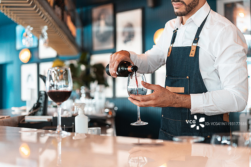 侍酒师在豪华酒店酒吧供应红酒图片素材