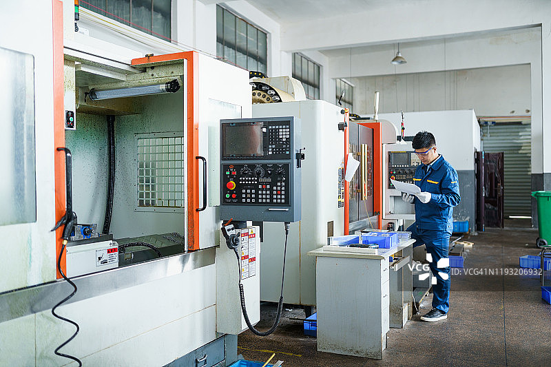 数控机床旁的工业工程师图片素材