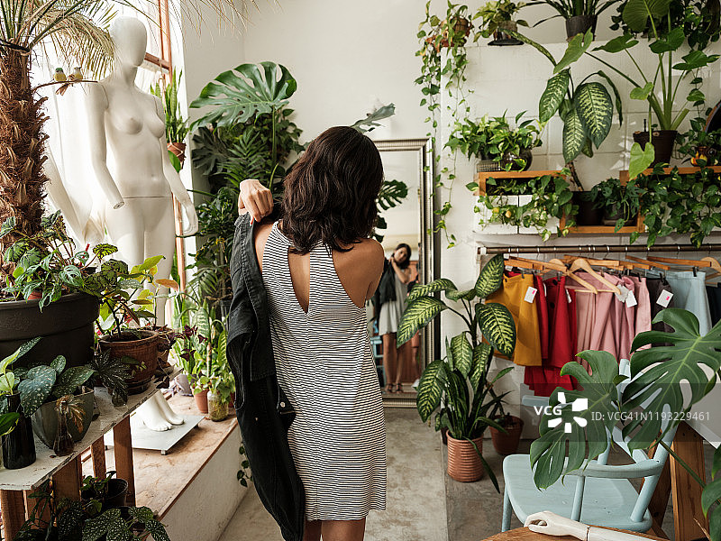 年轻女子在商店试穿衣服图片素材
