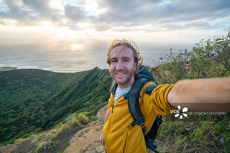 日出时自拍的年轻徒步男子图片素材