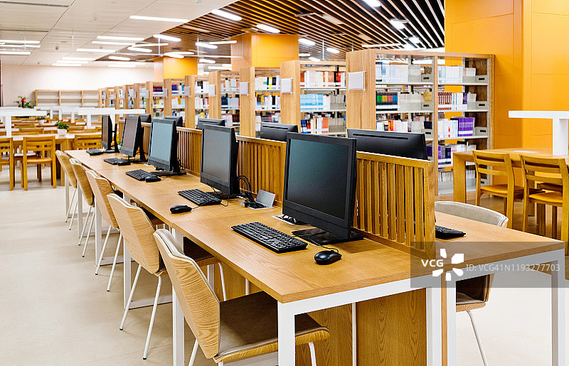 现代图书馆中的电脑和书架图片素材