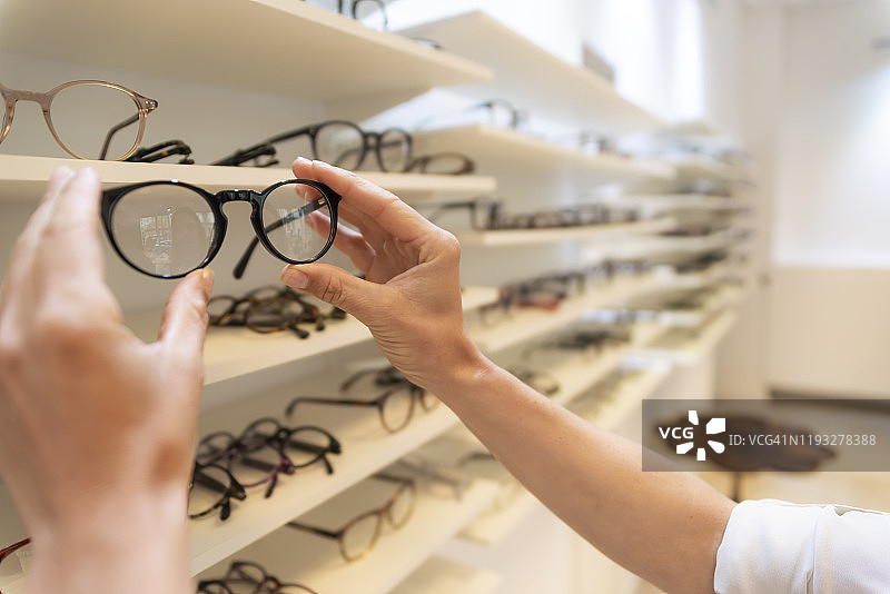 女性在眼镜店挑选眼镜特写图片素材