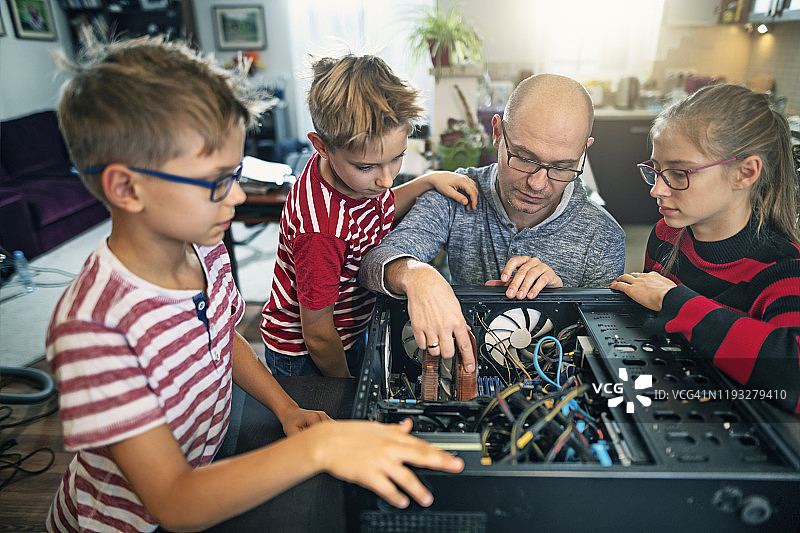 父亲向孩子们解释电脑内部结构图片素材