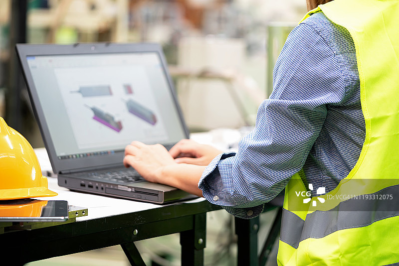 年轻女工程师用笔记本电脑检查装配零件图片素材