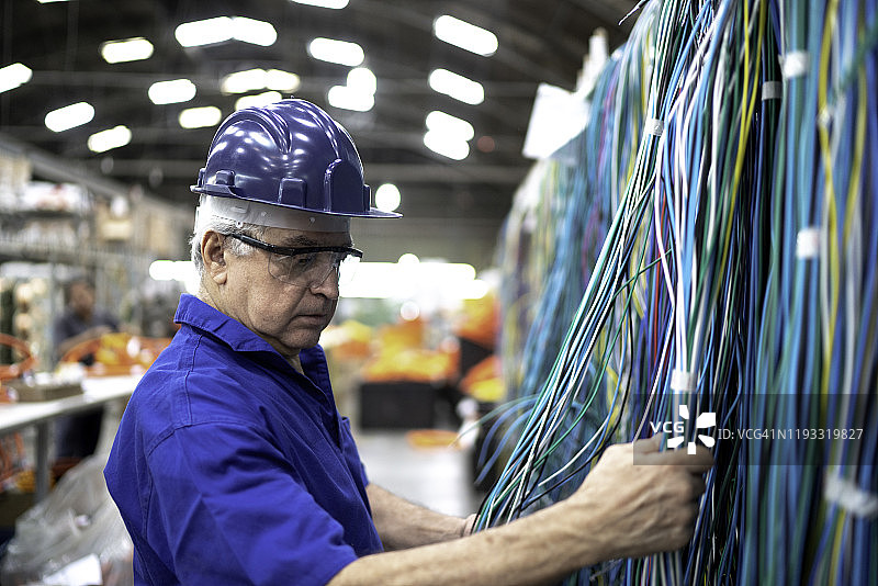 工程师在工厂检查电缆的侧视图图片素材