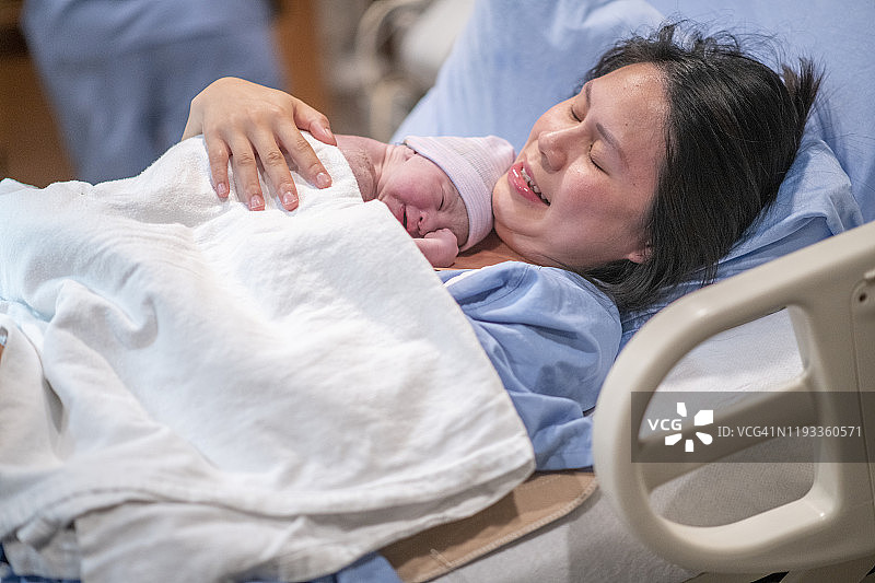 在分娩室与新生儿进行肌肤接触的亚洲母亲图片素材