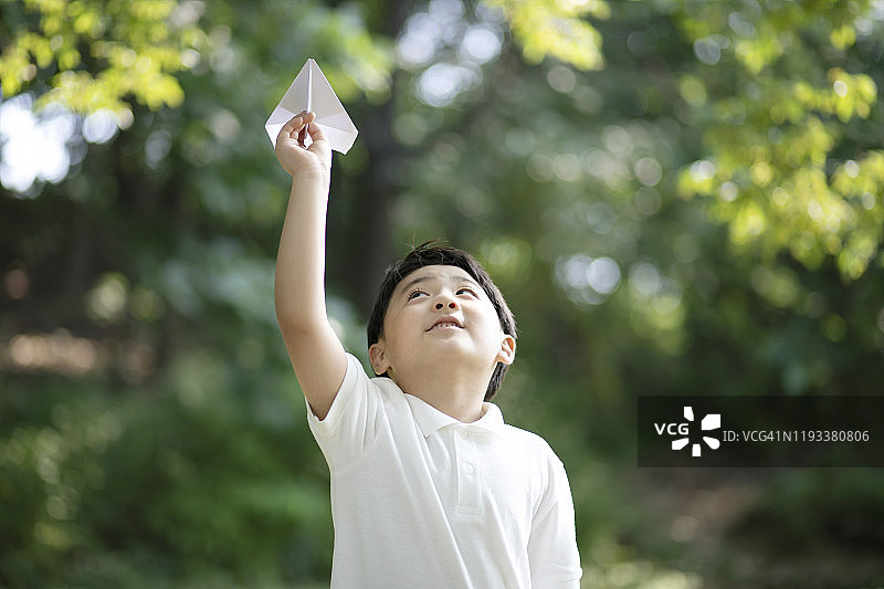 男孩在公园里拿着纸飞机图片素材