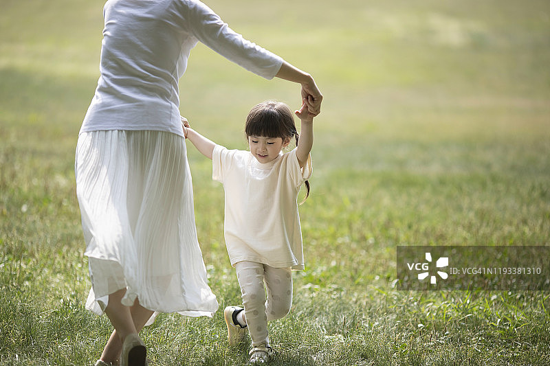 母女在草地上一起跳舞图片素材