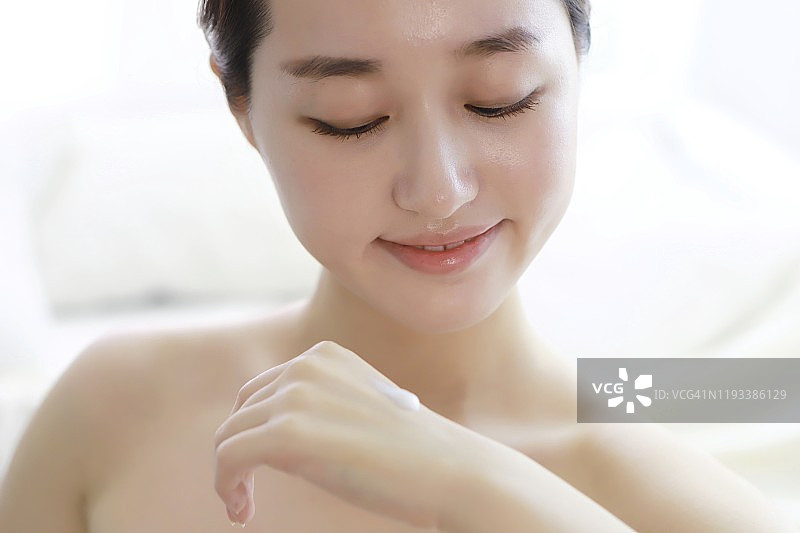 年轻女子涂抹护手霜图片素材