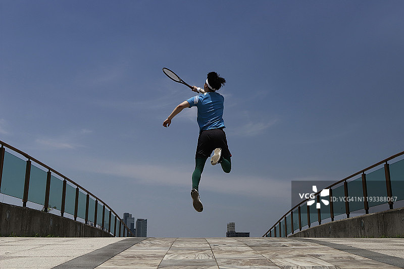 年轻男人挥动网球拍图片素材