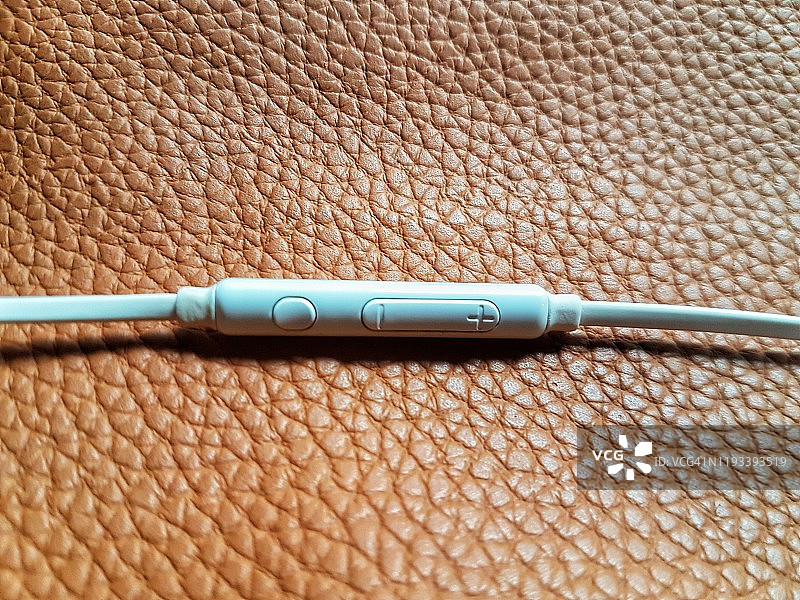 真皮背景上的入耳式耳机俯视图图片素材