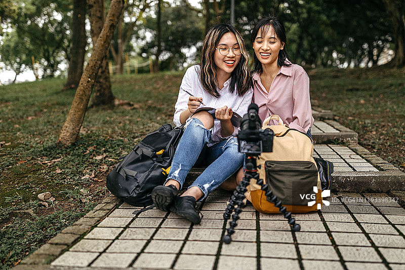 亚洲朋友在公园拍摄有趣的视频博客图片素材
