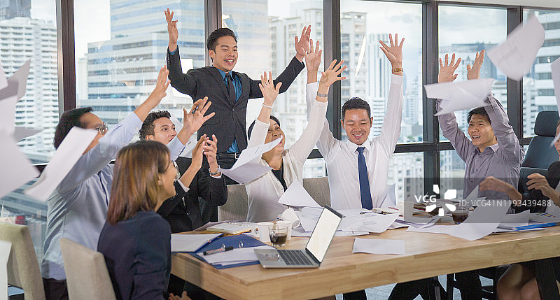 一群年轻的多民族人士在办公室的头脑风暴会议中手势击掌，欢笑和微笑。具有创业团队社区庆祝概念的休闲商务图片素材