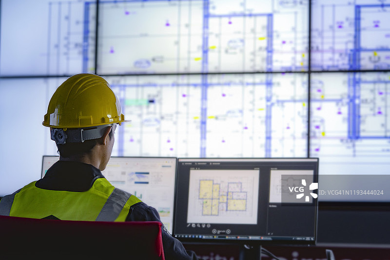 工业工程师在控制中心监控屏幕前工作，技术与AI理念图片素材