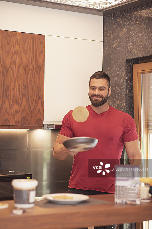 在厨房准备食物的男人：制作薄烤饼图片素材