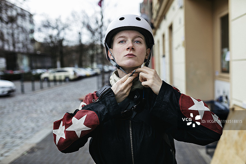 年轻女子出门骑自行车前戴头盔图片素材