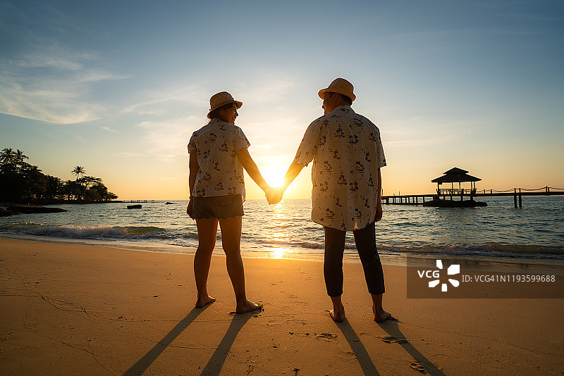 浪漫亚洲情侣海滩日落牵手蜜月图片素材