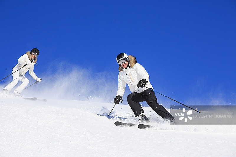 业余冬季运动高山滑雪：朋友们在阳光明媚的滑雪胜地滑雪。阿尔卑斯山欧洲意大利的高山雪景。图片素材