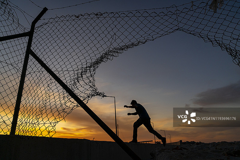 在栅栏后奔跑的难民图片素材