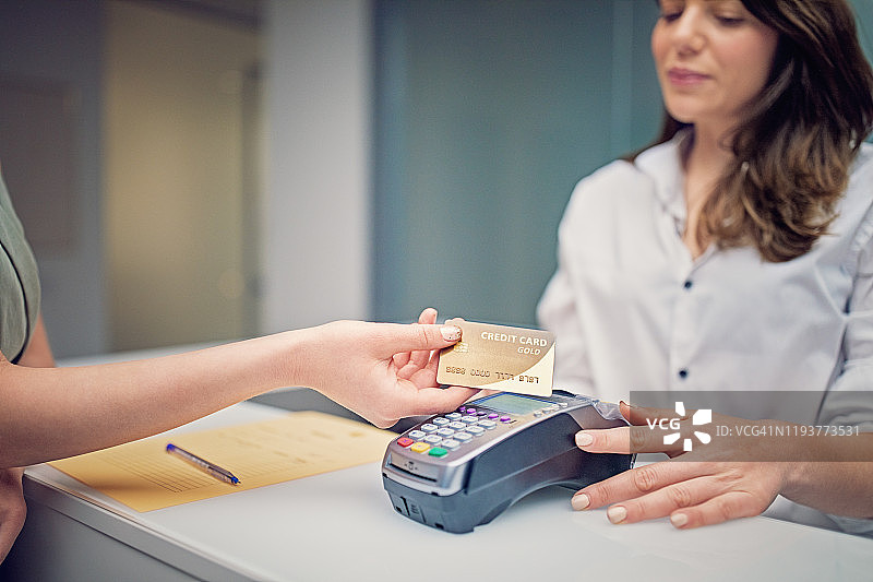 女人在美容院前台用非接触式信用卡支付图片素材