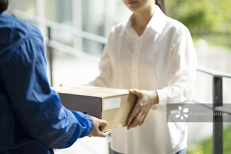 女子从中段收到送货员的包裹图片素材