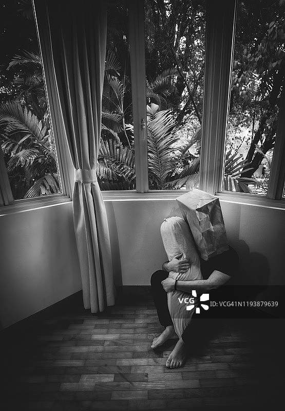 孤独：黑白影像，男子抱枕遮面图片素材