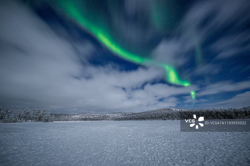 芬兰北部雪原和森林上美丽的极光图片素材
