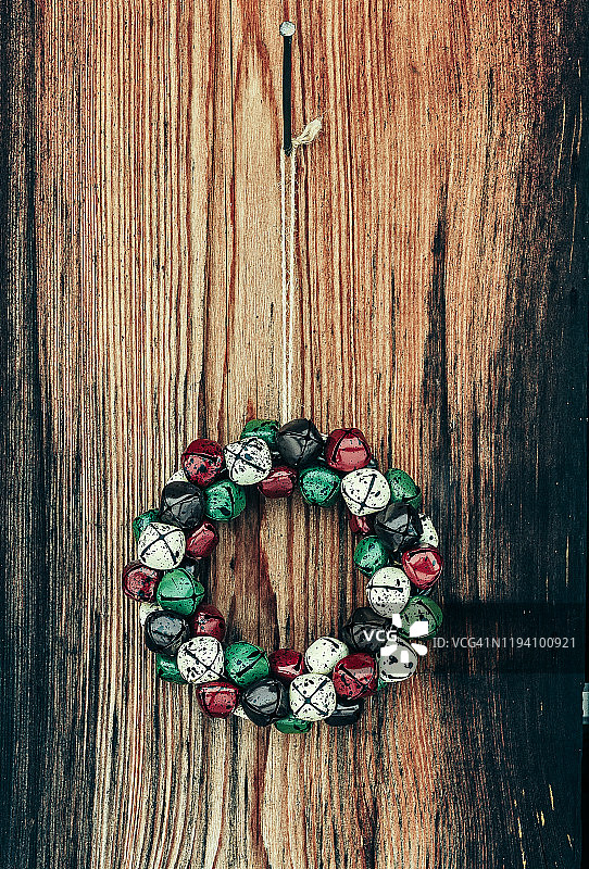 老旧棕色木门上的圣诞铃铛花环图片素材