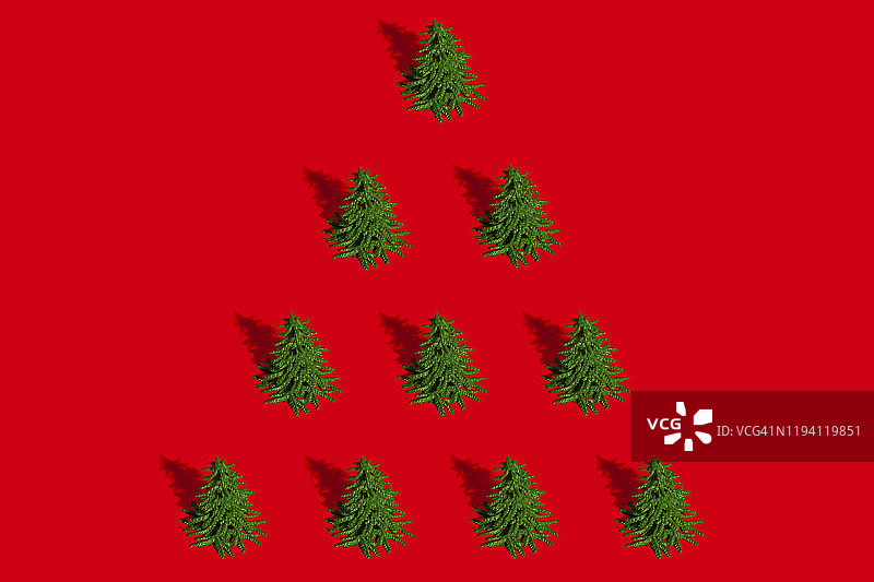 红色背景上的绿色圣诞树的极简主义构图背景。圣诞节和新年概念图片素材