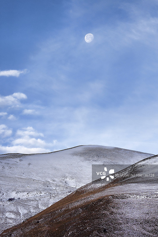 黎明时分雪山之上的月亮图片素材