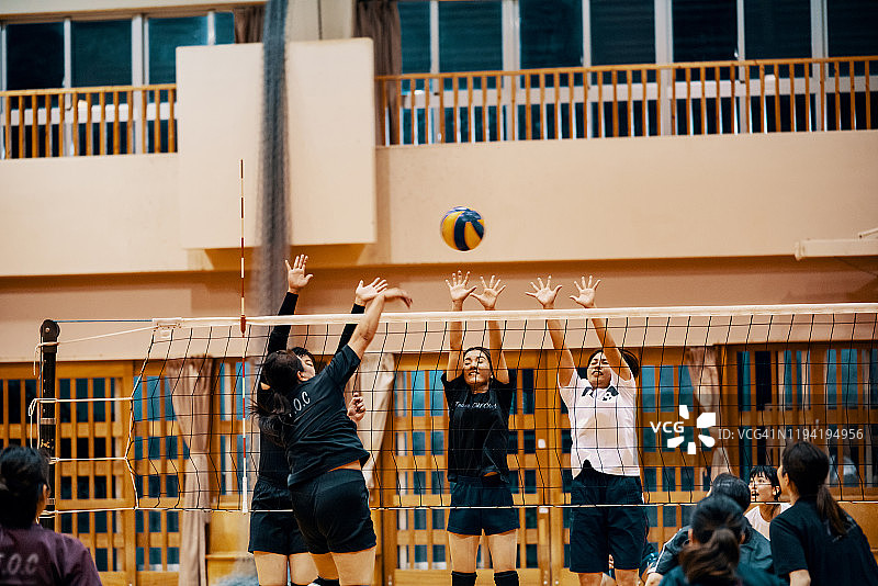在社区联赛中一起打排球的各年龄段妇女图片素材