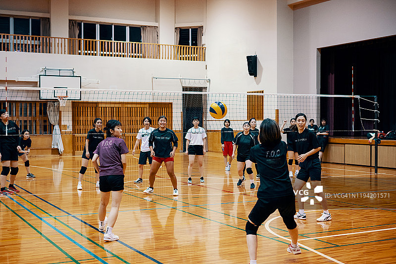 在社区联赛中一起打排球的各年龄段妇女图片素材