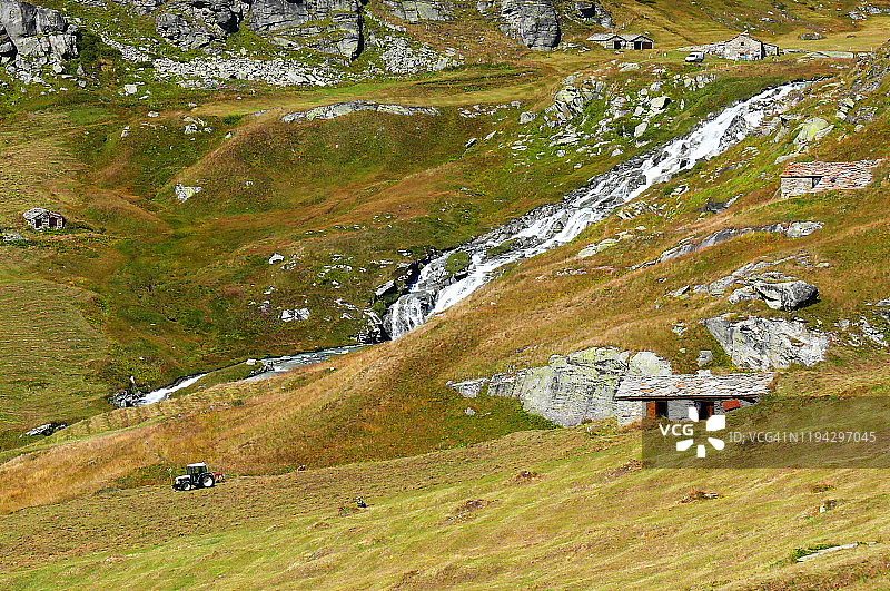 法国萨瓦省阿尔卑斯山牧场上的干草收割图片素材