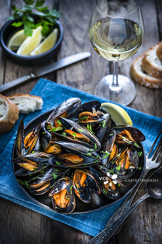 乡村木桌上的白葡萄酒蒸贻贝图片素材