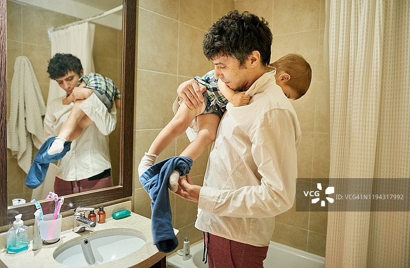 父亲给儿子穿衣服图片素材