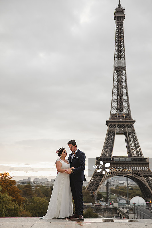 一对新婚夫妇在埃菲尔铁塔下欢笑图片素材