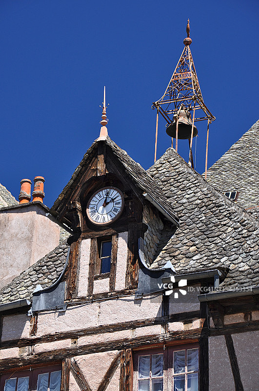 半木结构房屋石板屋顶上的旧钟和铃铛图片素材