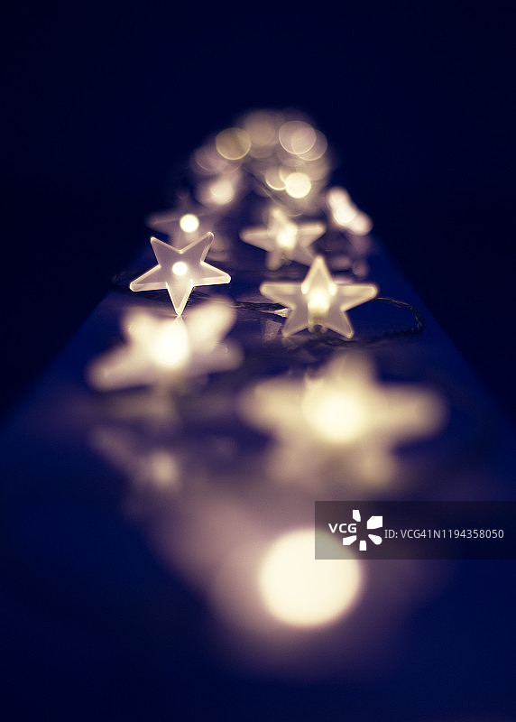 星形圣诞装饰灯，具有厚重的散景效果，背景为深色。图片素材