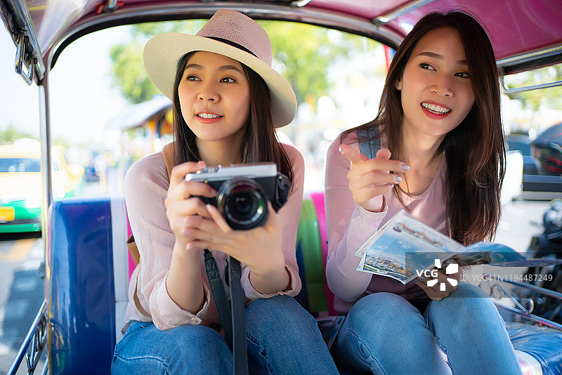 在泰国嘟嘟车上看向镜头的年轻漂亮的亚洲女性图片素材