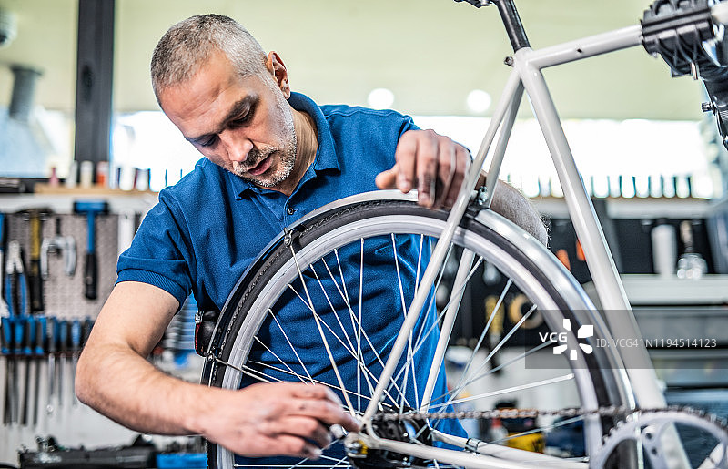 技术员在自行车修理店修理自行车变速器。图片素材