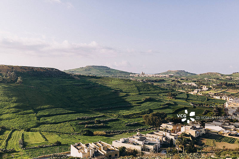 从戈佐岛内陆眺望山丘、田野、乡村和教堂，马耳他戈佐岛图片素材